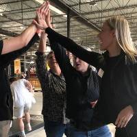 Two people doing a high five at an Alumni Social
